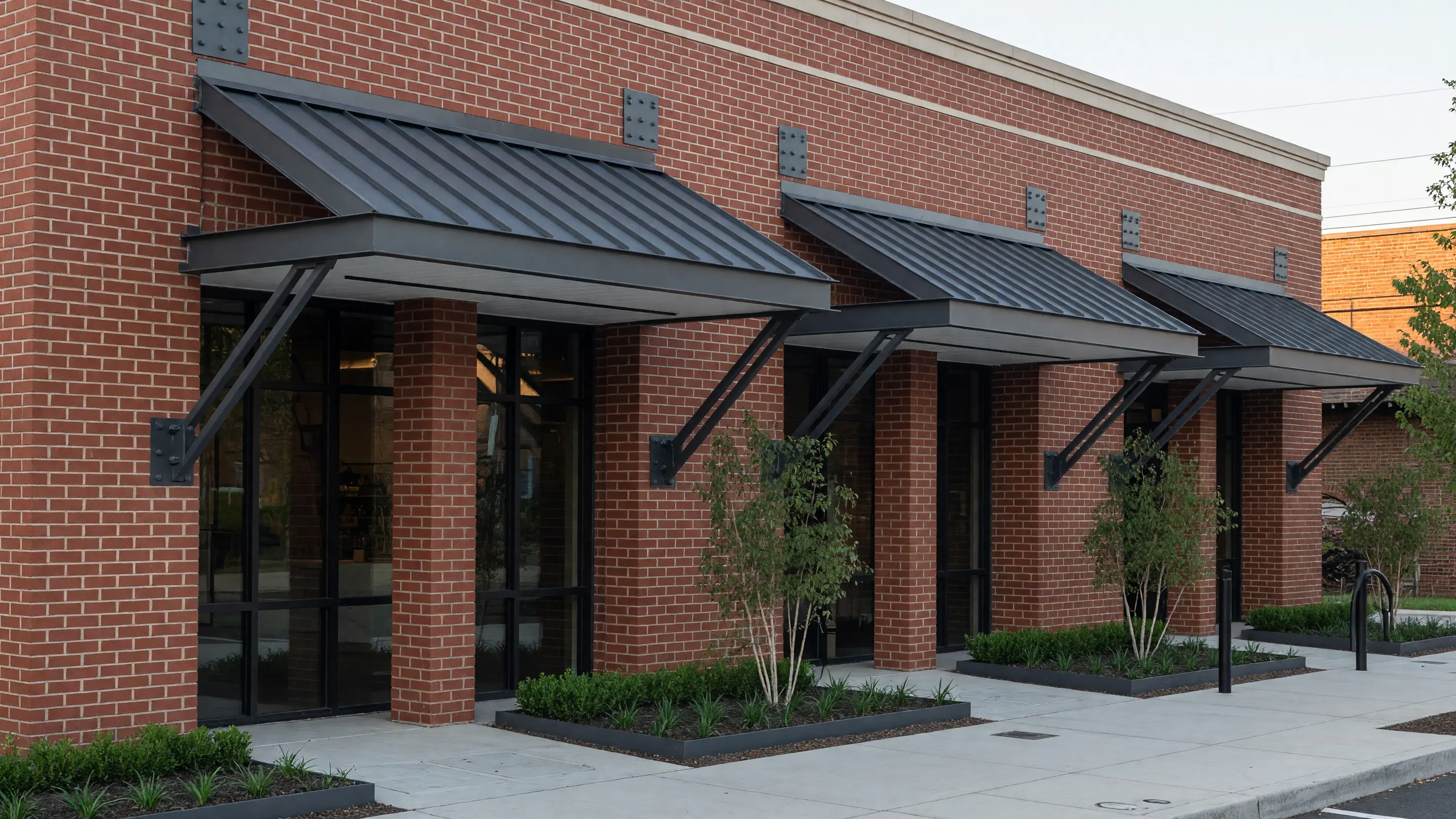 Repeated fixed steel canopies defining a small brick commercial facade